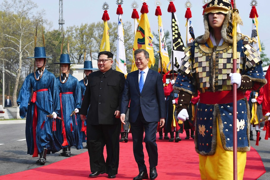 Kim Jong-un (left) and Moon Jae-in walk together at the border village of Panmunjom.