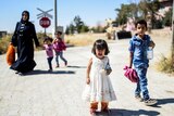 Syrian refugees walk back to the Syrian city of Jarabulus.