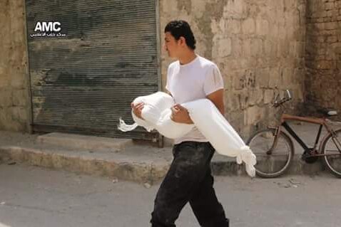 A dead body is carried after a bomb attack