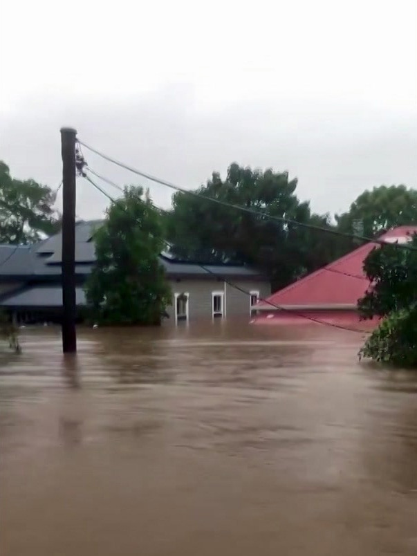 Homes in a flood have water up to the roof.