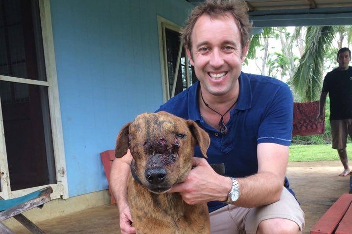 Geoff Neal, SPAW's lead veterinarian, with a Tonga they have helped treat there. The dog has a misshapen head and one eye.