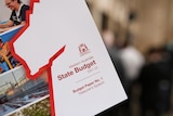 A close-up of a WA Budget paper with a red outline of the state.