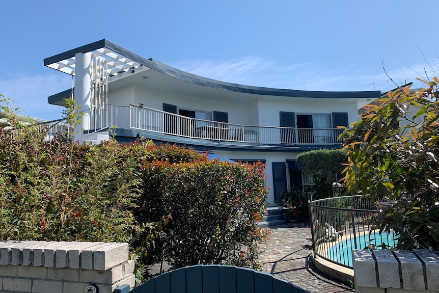 A 1950s-era two-storey house with a decorative spiral staircase and a pool.