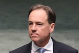 Greg Hunt walks into the House of Representatives and looks towards the Opposition's benches