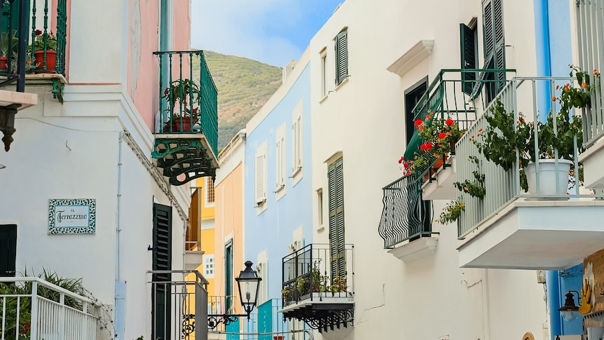 A colourful Italian streetscape with pastel coloured buildings and balconies. 