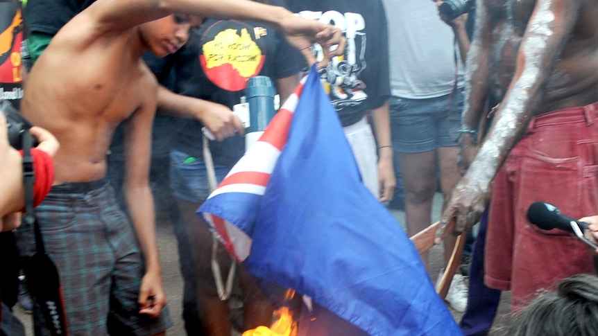 Young Aboriginal protesters from the Tent Embassy burn the Australian flag outside Parliament House.