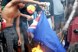 Young Aboriginal protesters from the Tent Embassy burn the Australian flag outside Parliament House.