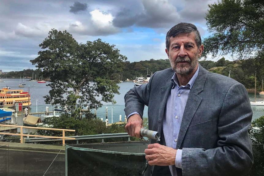 A man stands on a balcony overlooking Berrys Bay.