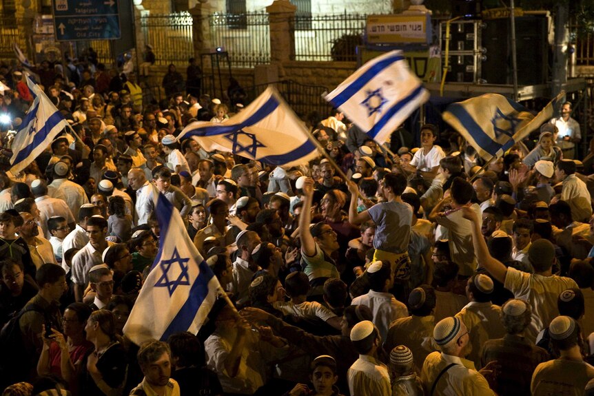 Israeli right-wing activists wave Israel national flag during a rally