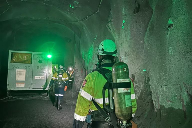 an emergency responder walks in dim underground light