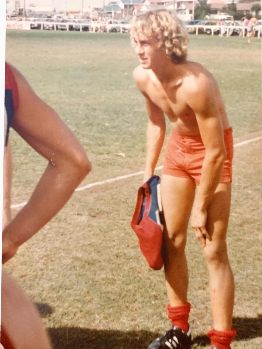 Trevor Foster stands on the footy field with his shirt off.