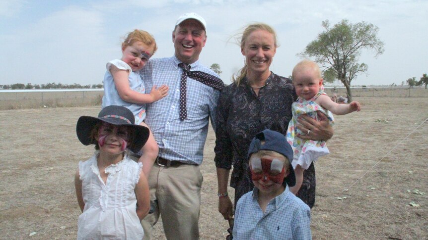 Ben and Lara Hawke pictured at the Come by Chance racecourse, with their four young children.