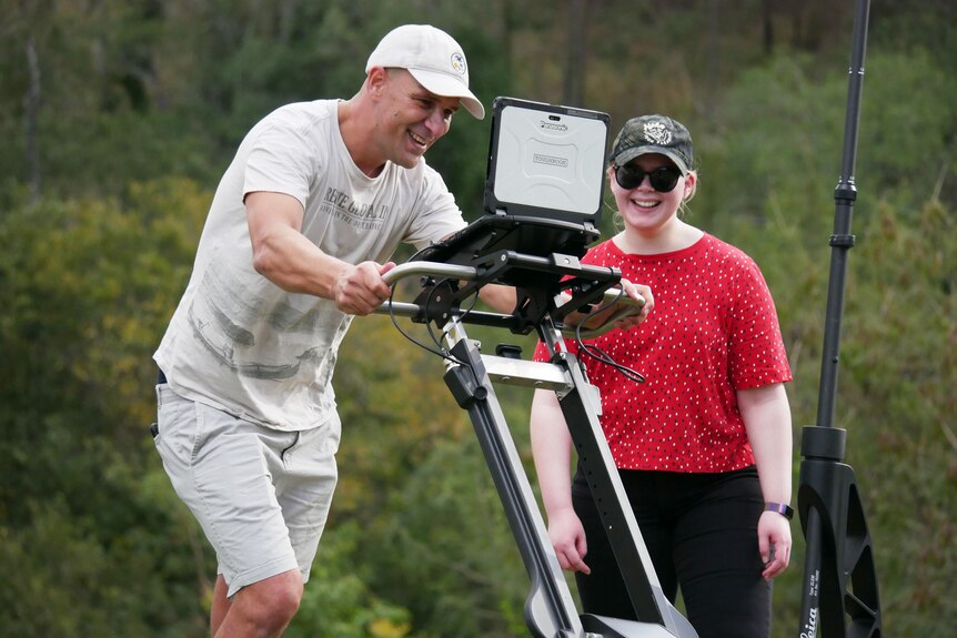 Daniel Thompson smiles as he pushes a Ground Penetrating Radar scanner at Shapcott Park in Ipswich, west of Brisbane.