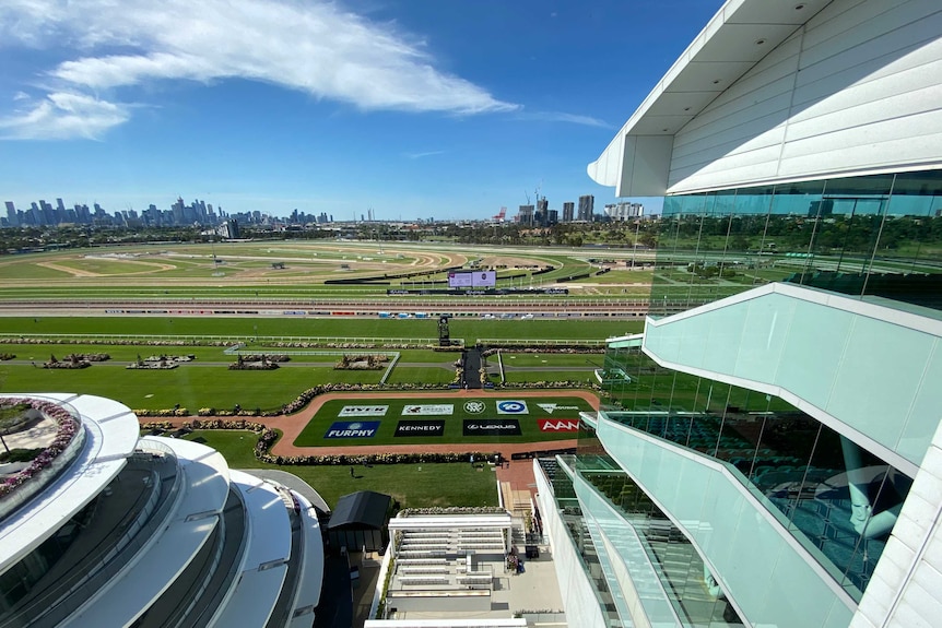 Building and race tracks empty on a summer's day with city skyline in the background.