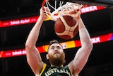The ball is just through the hoop as Aron Baynes completes the dunk. Two Canadian players look on.