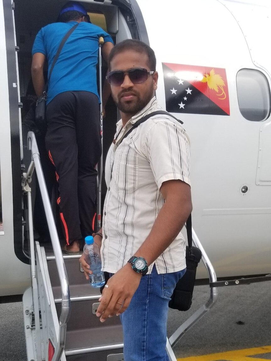 Shaminda Kanapathi, a Sri Lankan refugee who has been held on Manus, stands on the stairs of a Port Moresby-bound charter plane.