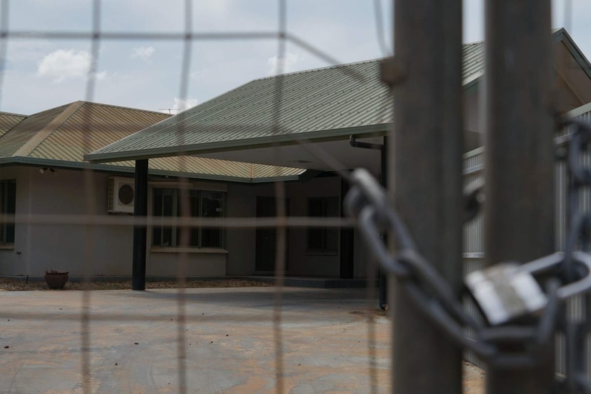 A photo of a house in Darwin's rural area, fenced off and padlocked.