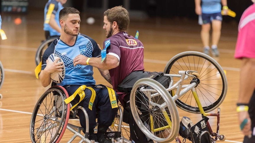 Two men playing football in wheelchairs.