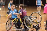 Two men playing football in wheelchairs.