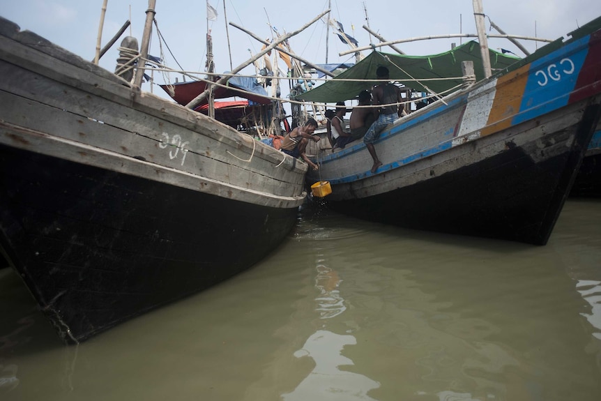 Rohingya men sit inside boats at a refugee camp in Myanmar's Rakhine State