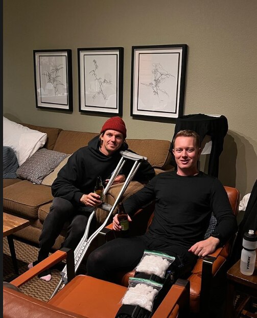 Man with crutches and another man with ice on his leg 