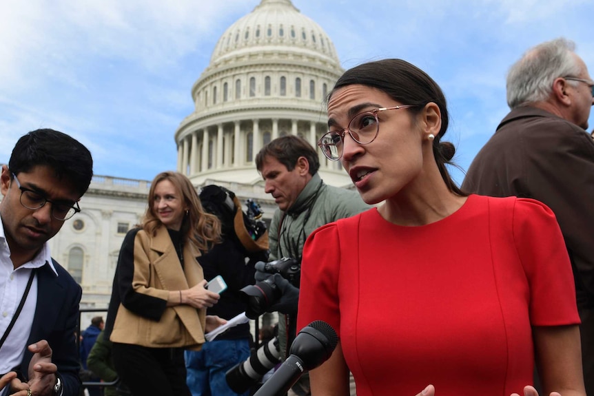 Elected congresswoman Alexandria Ocasio-Cortez talks to a reporter in front of the Capitol Building