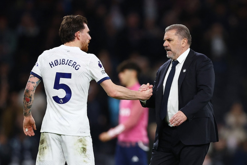 Tottenham Hotspur's player Pierre-Emile Hojbjerg and manager Ange Postecoglou celebrate by clasping hands and embracing