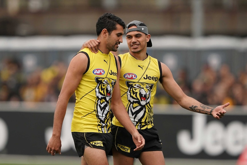 Two Tigers AFL players chat on field