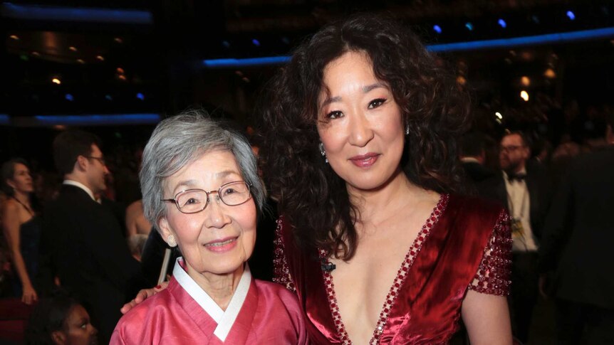Sandra Oh stands with her mother inside the awards ceremony.