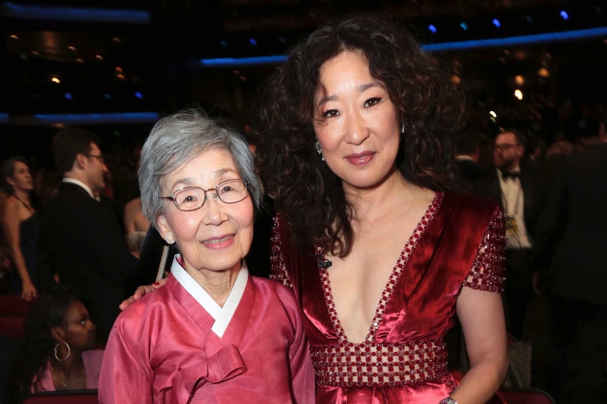 Sandra Oh stands with her mother inside the awards ceremony.