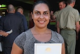 Annie Johnstone displays her certificate at the official enlistment of new Army trainees in Darwin.