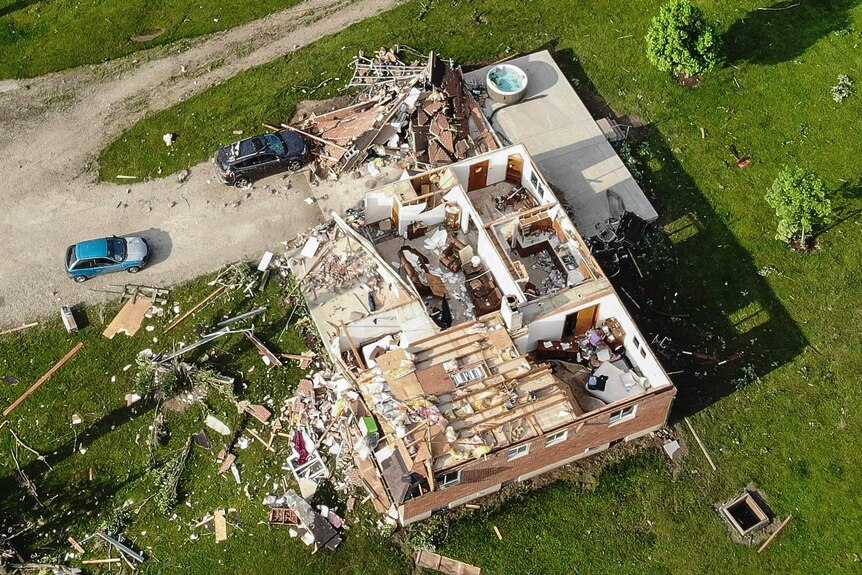 Aerial shot showing roof blown off a building and debris scattered about