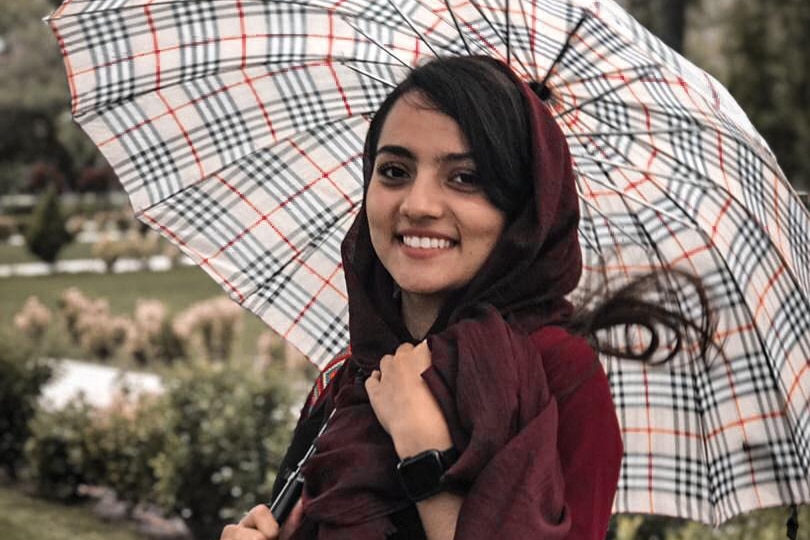 A young woman holds an umbrella