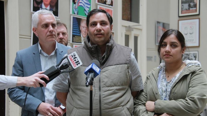 TWU national secretary Michael Kaine, with Uber delivery drivers Santosh and Amita Gupta at a press conference.