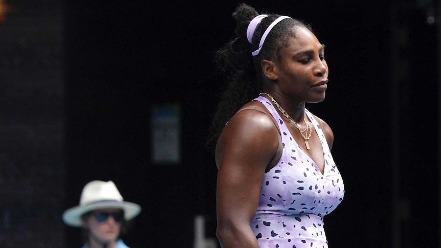 A dejected tennis player looks down at the court after she is knocked out of the Australian Open.