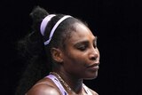 A dejected tennis player looks down at the court after she is knocked out of the Australian Open.