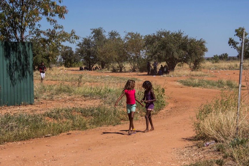 The back streets of Fitzroy Crossing with two girls walking along