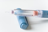 A close-up of a blue injector pen.