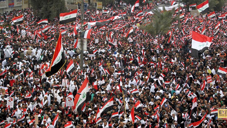 Thousands of supporters in Baghdad carrying flags.