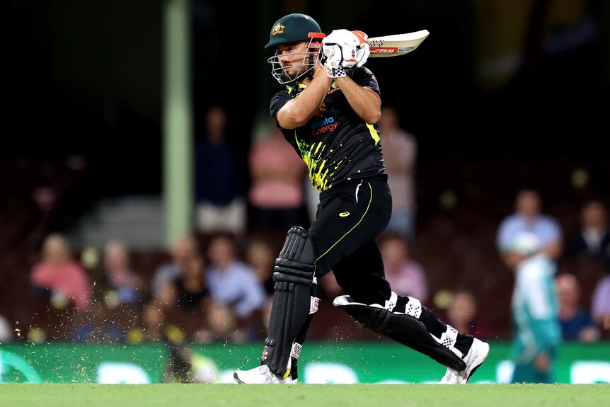 An Australian male batter hits the ball to the leg side during a T20 international against Sri Lanka.
