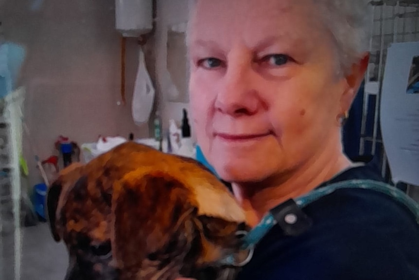 A veterinary nurse holding a dog.