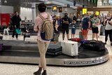 People wait for their luggage at the baggage carousel at Brisbane Airport on Easter Monday.