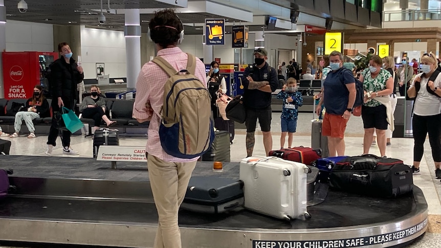 People wait for their luggage at the baggage carousel at Brisbane Airport on Easter Monday.