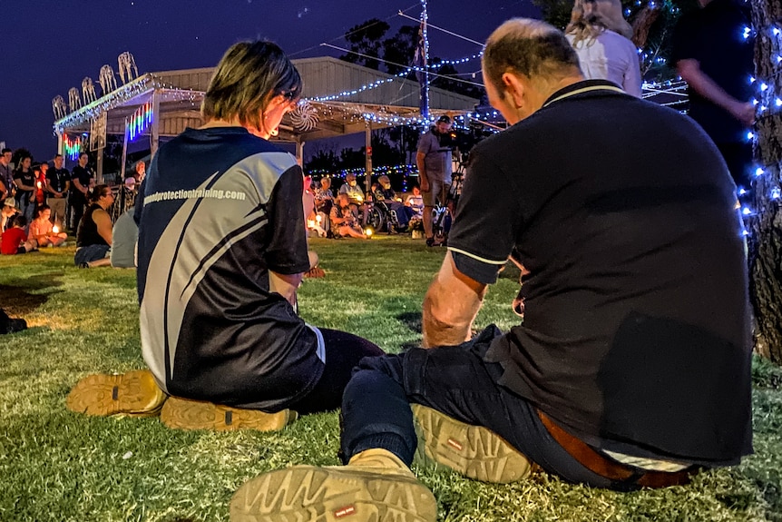 two people sitting on grass