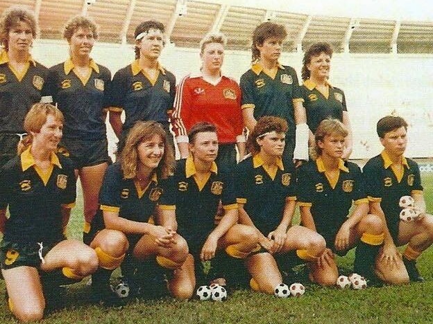 A soccer team wearing green and yellow line up for a photo before playing a game