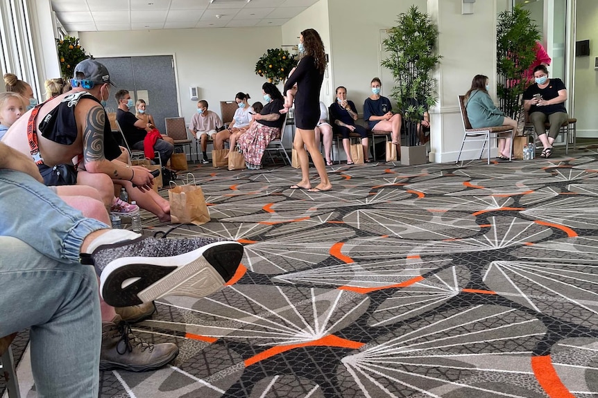 A room lined with people on chairs