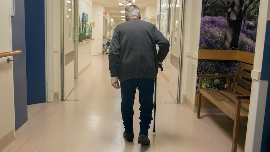 An elderly man walks down the corridor of a secure ward in Sunshine Hospital.