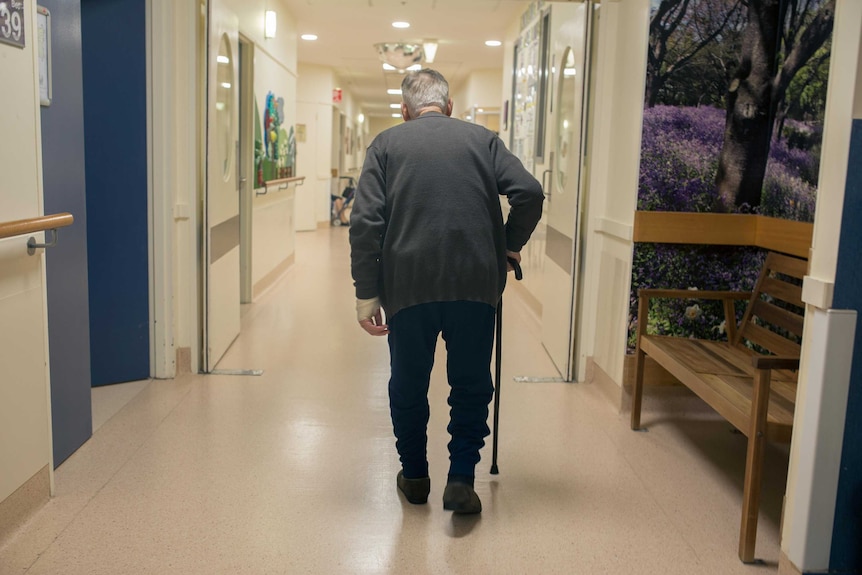 An elderly man walks down the corridor of a secure ward in Sunshine Hospital.