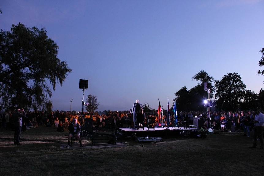 People in a crowd watching someone on stage.