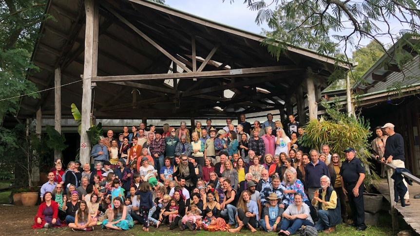 a large group of people in front of a wooden building